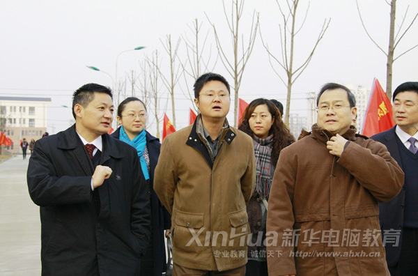 人大代表們聽取新華教育集團領導(左)介紹新校區
